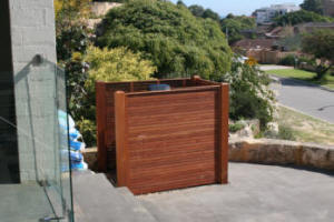 Pool filter unit to side of house - but screened with slatted timber panels